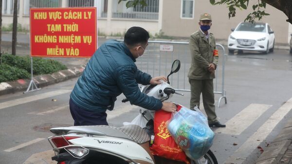 Người nhà gửi đồ tiếp tế cho người bên trong khu cách ly.  - Sputnik Việt Nam