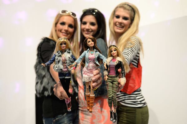 Những người mẫu tạo dáng với búp bê Barbie mặc trang phục tương tự, tại quầy Mattel trong Triển lãm đồ chơi quốc tế ở Nieders - Sputnik Việt Nam