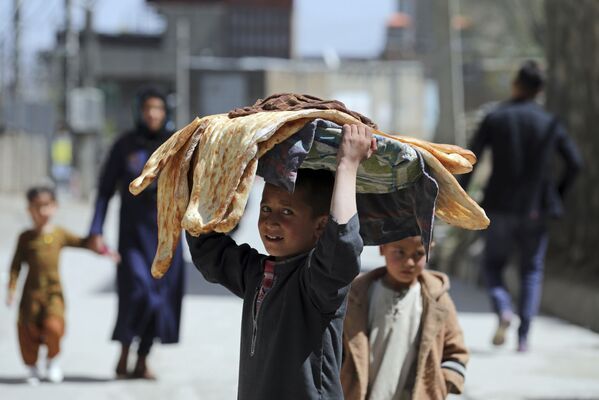 Cậu bé với bánh mì Lavash trên đầu ở một đường phố Kabul, Afghanistan - Sputnik Việt Nam