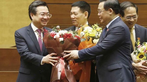 Chủ tịch Quốc hội Vương Đình Huệ tặng hoa chúc mừng Bộ trưởng Bộ Xây dựng Nguyễn Thanh Nghị. - Sputnik Việt Nam