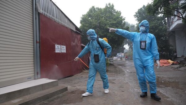 Nhân viên y tế phun khử khuẩn tại khu vực gần ca nghi nhiễm. - Sputnik Việt Nam