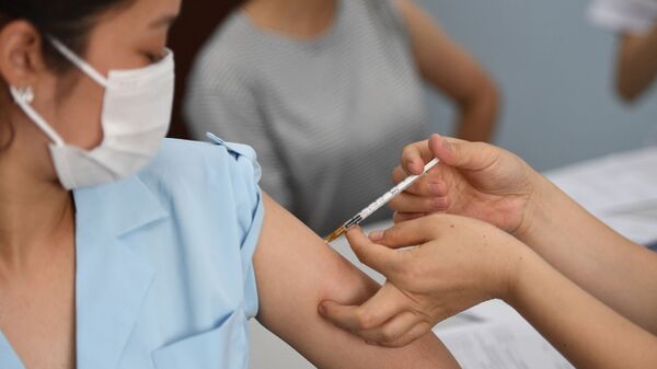 Người phụ nữ được tiêm  vắc xin AstraZeneca tại Bệnh viện Bạch Mai, Hà Nội - Sputnik Việt Nam