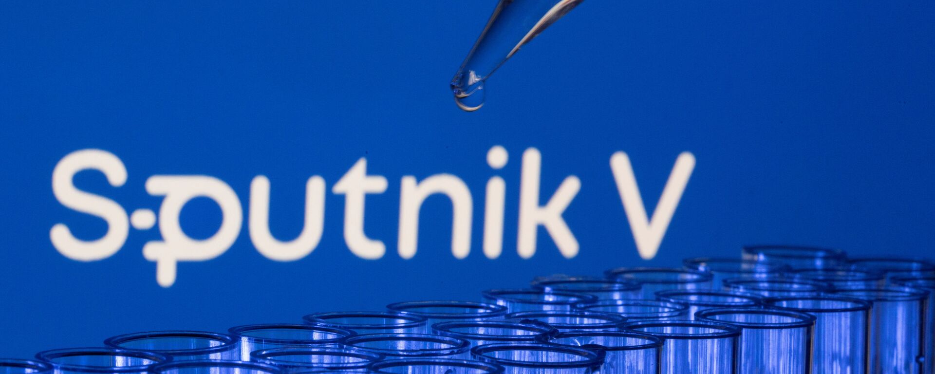 Các ống est được nhìn thấy phía trước logo Sputnik V được hiển thị trong hình minh họa này được chụp, ngày 21 tháng 5 năm 2021. - Sputnik Việt Nam, 1920, 03.12.2021