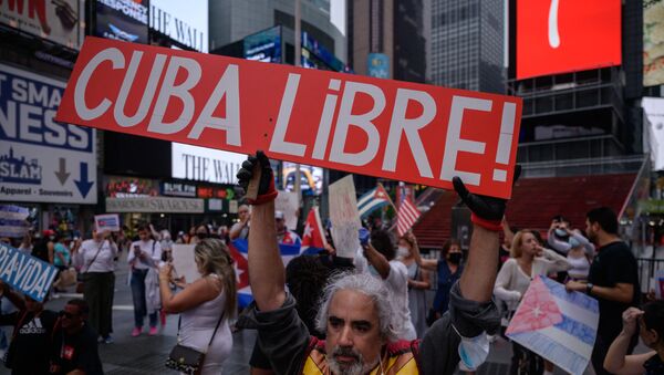 Người biểu tình cầm biểu ngữ trong một cuộc mít tinh được tổ chức đoàn kết với các cuộc biểu tình chống chính phủ ở Cuba, tại Quảng trường Thời đại, New York vào ngày 13 tháng 7 năm 2021. - Một người chết và hơn 100 người khác, bao gồm các nhà báo độc lập và nhà bất đồng chính kiến, đã bị bắt sau khi chưa từng có tiền lệ Các nhà quan sát và các nhà hoạt động cho biết các cuộc biểu tình chống chính phủ ở Cuba, với một số người còn lại bị giam giữ hôm thứ Ba. - Sputnik Việt Nam