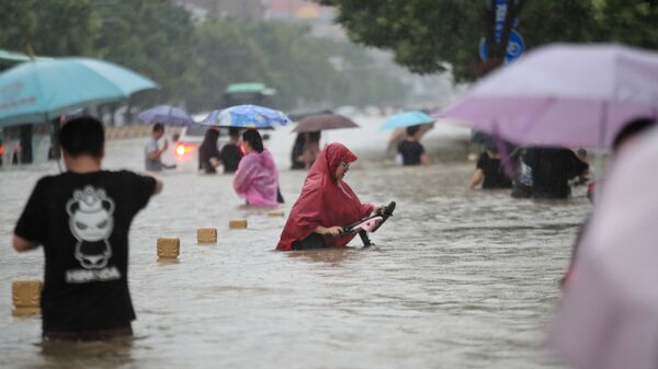 Người dân Trung Quốc trên những đường phố ngập lụt ở thành phố Trinh Châu, tỉnh Hà Nam, Trung Quốc, ngày 20/7/2021 - Sputnik Việt Nam