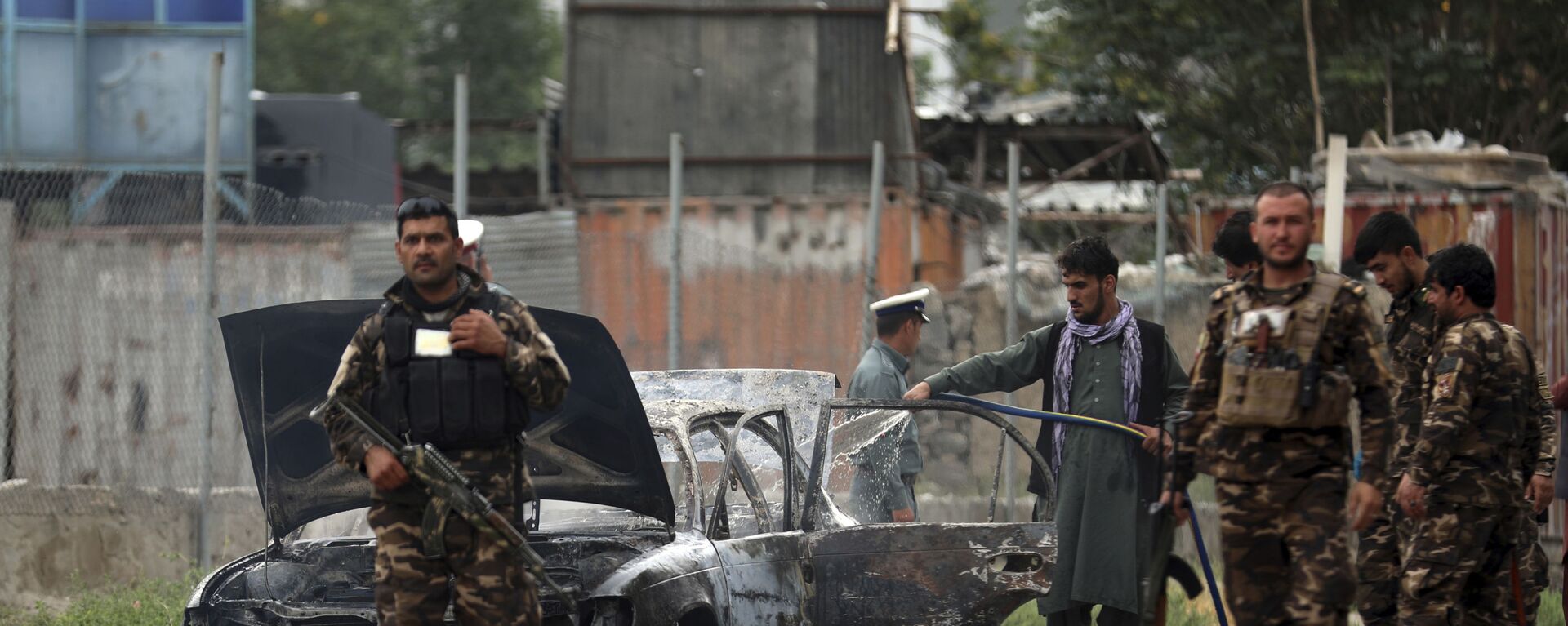 Nhân viên an ninh kiểm tra một chiếc xe bị hư hại trong cuộc pháo kích vào Kabul - Sputnik Việt Nam, 1920, 18.09.2021
