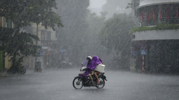 Người dân đi xe tay ga trong cơn mưa tầm tã ở Hà Nội, Việt Nam  - Sputnik Việt Nam