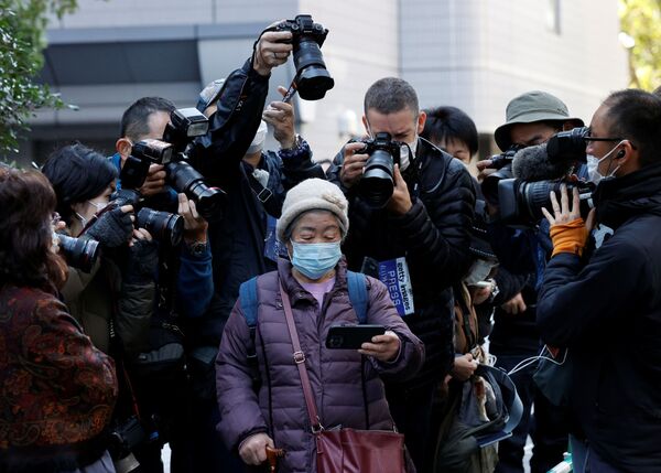 Các nhiếp ảnh gia ghi lại cảnh người phụ nữ theo dõi truyền hình trực tiếp buổi họp báo của công chúa Nhật Bản Mako và phu quân Kei Komuro - Sputnik Việt Nam