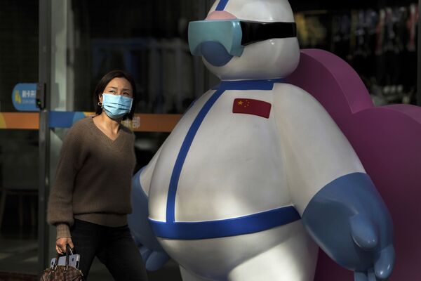 Người phụ nữ đi qua bên cạnh hình nhân mô tả nhân viên y tế ở Bắc Kinh, Trung Quốc. - Sputnik Việt Nam