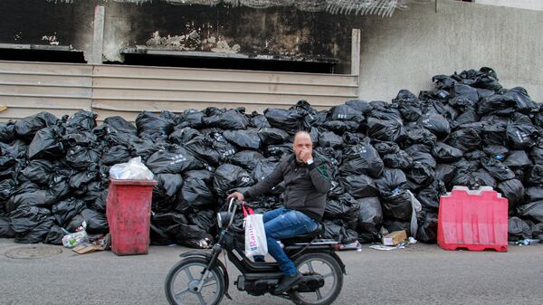 Bịt mũi khi lái xe qua những túi rác chất thành đống ở trung tâm thành phố Sfax, Tunisia - Sputnik Việt Nam