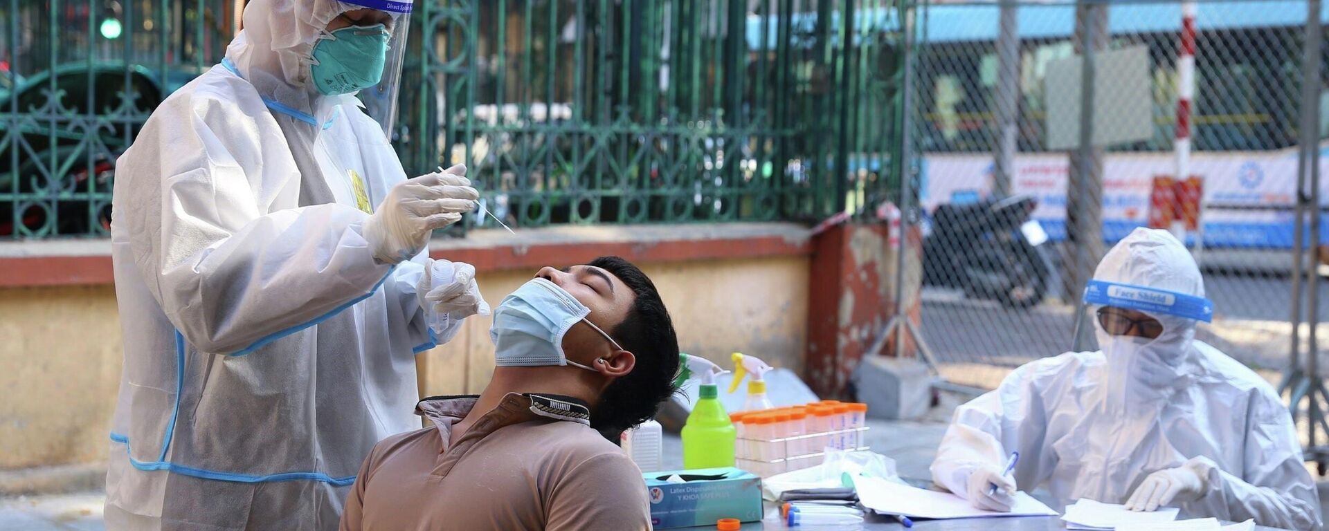 Nhân viên y tế lấy mẫu xét nghiệm sàng lọc COVID-19 cho người dân trong khu vực bị phong tỏa thuộc phường Nguyễn Du (Hà Nội) - Sputnik Việt Nam, 1920, 01.01.2022