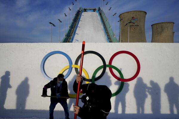Hai công nhân chuẩn bị cầu nhảy cho buổi tập của các vận động viên trước cuộc thi trượt tuyết tự do tại Thế vận hội mùa đông 2022 ở Bắc Kinh - Sputnik Việt Nam