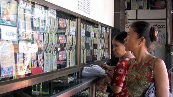 Người dân Myanmar xem vé số tại một ki-ốt ở Yangon, Myanmar - Sputnik Việt Nam