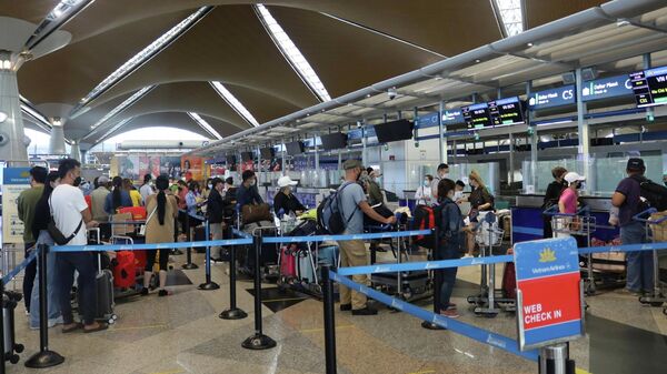 Hành khách làm thủ tục ngày 17/2/2022 tại sân bay quốc tế Kuala Lumpur, Malaysia để lên chuyến bay VN674. - Sputnik Việt Nam