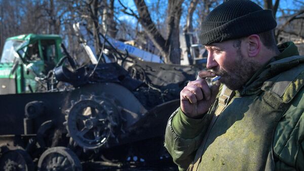 Một quân nhân của Dân quân Nhân dân DNR hút thuốc khi đứng gần một thiết bị quân sự bị phá hủy ở thành phố Volnovakha thuộc quyền kiểm soát của Cộng hòa Nhân dân Donetsk, DNR. - Sputnik Việt Nam