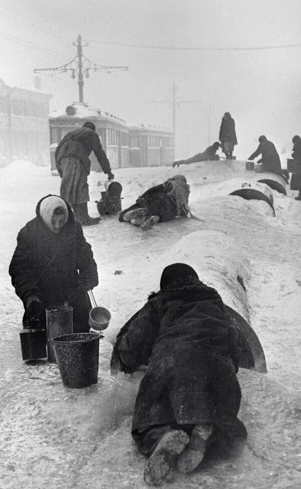 Cư dân thành phố Leningrad trong vòng phong toả lấy nước từ đường ống bị vỡ trên con phố băng giá. - Sputnik Việt Nam