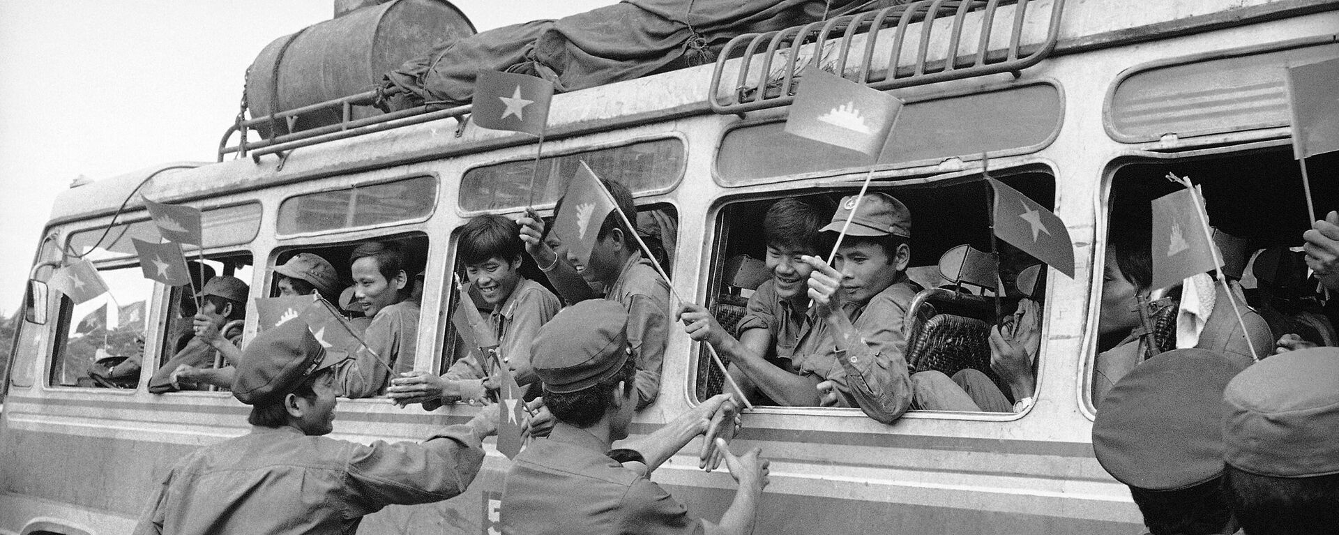 Các binh sĩ Campuchia chào tạm biệt quân đội Việt Nam trên xe buýt khi họ rời Phnom Penh, Campuchia, 1982 - Sputnik Việt Nam, 1920, 11.09.2022