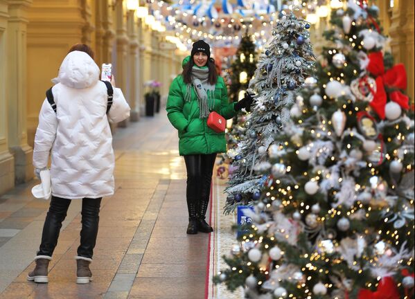 Cô gái chụp ảnh bên những cây thông Noeltrang trí đón Năm Mới ở GUM. - Sputnik Việt Nam