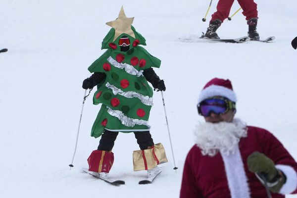 Vận động viên trượt tuyết hóa trang thành cây thông Noel trong buổi chạy bộ từ thiện tại Khu trượt tuyết Sandy River, Hoa Kỳ. - Sputnik Việt Nam