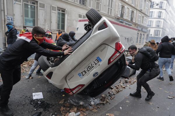 Người biểu tình lật đổ chiếc ô tô trong cuộc biểu tình phản đối vụ nổ súng ở trung tâm Paris, Pháp. - Sputnik Việt Nam