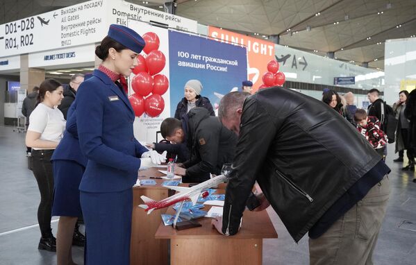 Các nhân viên sân bay tổ chức xổ số lễ hội tại các sự kiện vinh danh kỷ niệm 100 năm ngành Hàng không Dân dụng tại phi trường «Pulkovo». - Sputnik Việt Nam