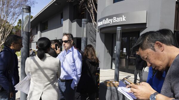 Thành viên FDIC Dedra Dorn (giữa bên trái) nói chuyện với những người xếp hàng bên ngoài trụ sở Silicon Valley Bank   ở Santa Clara, California. - Sputnik Việt Nam