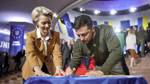 Tổng thống Ukraina Vladimir Zelensky (phải) và Chủ tịch Ủy ban châu Âu Ursula von der Leyen viết lời chúc trên lá cờ Ukraina trong hội nghị thượng đỉnh Ukraina-EU ở Kiev. - Sputnik Việt Nam