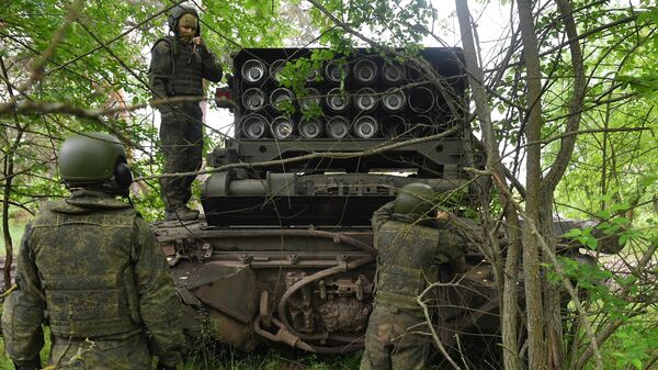 Thành viên tổ điều khiển bên gần hệ thống súng phun lửa hạng nặng TOS-1A Solntsepyok của Lực lượng Vũ trang Nga trong khu vực diễn ra chiến dịch quân sự đặc biệt. - Sputnik Việt Nam