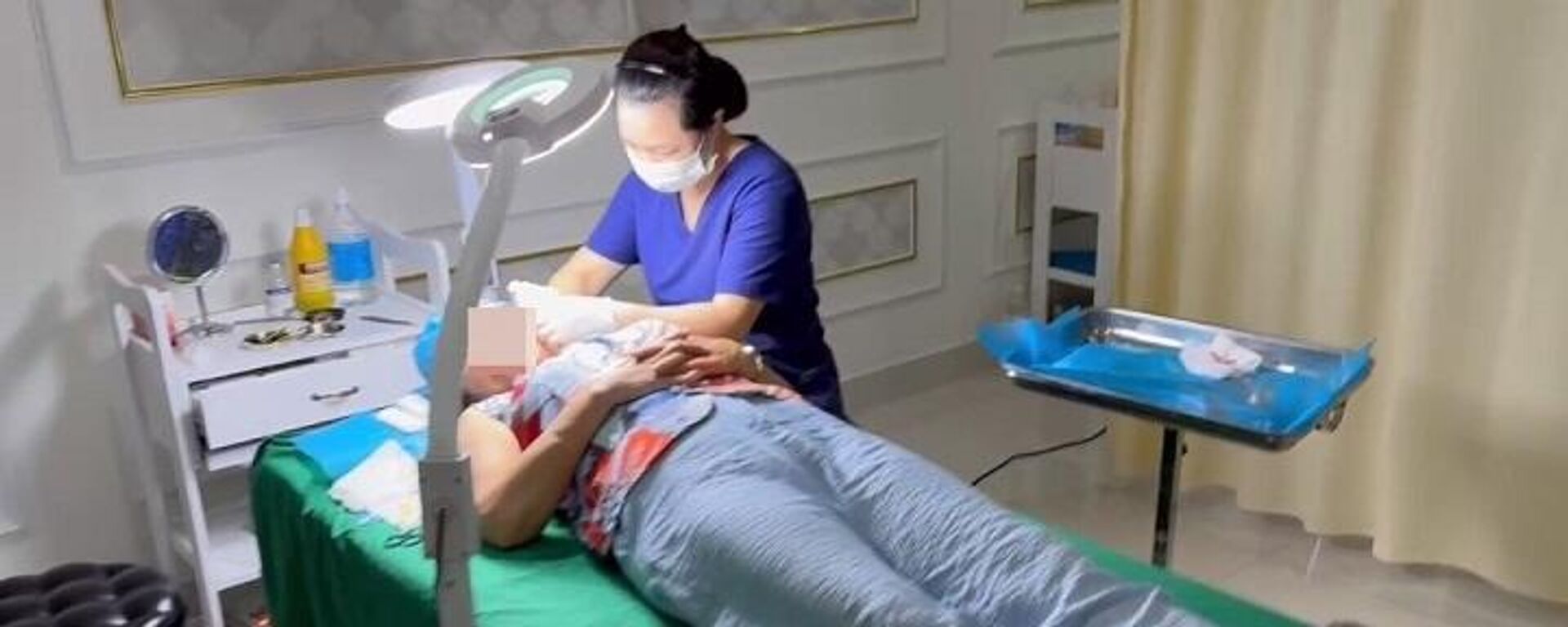 Nữ lao công T.T.T của thẩm mỹ viện Kangzin đang phẫu thuật căng da mặt cho khách. - Sputnik Việt Nam, 1920, 14.08.2023