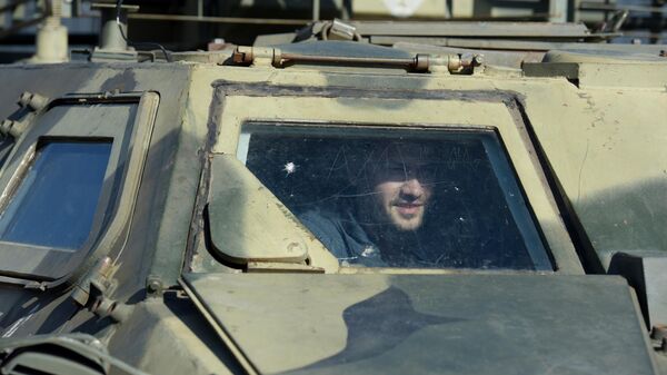Một người đàn ông bên trong xe bọc thép chở quân của lực lượng vũ trang Ukraina ở Lugansk - Sputnik Việt Nam