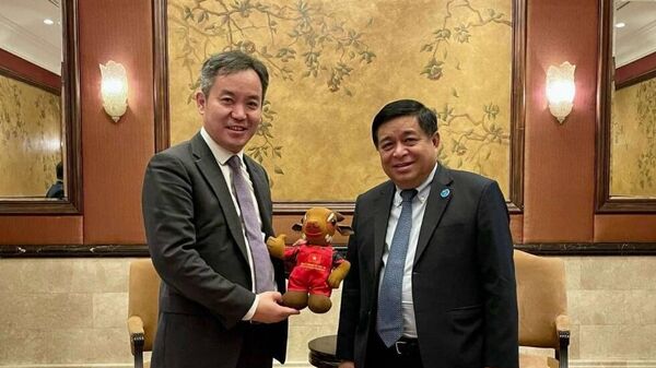 Bộ trưởng Nguyễn Chí Dũng tặng quà lưu niệm cho ông Bạch Ngọc Chiến - Sputnik Việt Nam