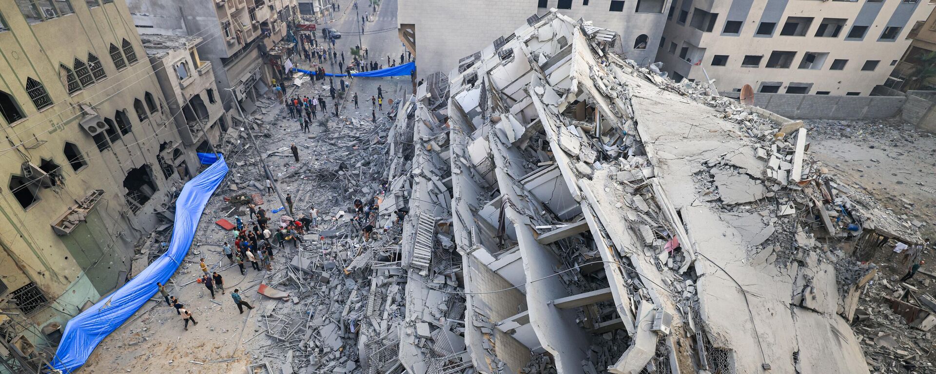 Người dân tìm kiếm trong đống đổ nát tòa nhà bị phá hủy sau cuộc không kích của Israel ở thành phố Gaza - Sputnik Việt Nam, 1920, 03.11.2023