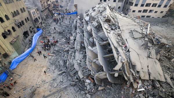 Người dân tìm kiếm trong đống đổ nát tòa nhà bị phá hủy sau cuộc không kích của Israel ở thành phố Gaza - Sputnik Việt Nam