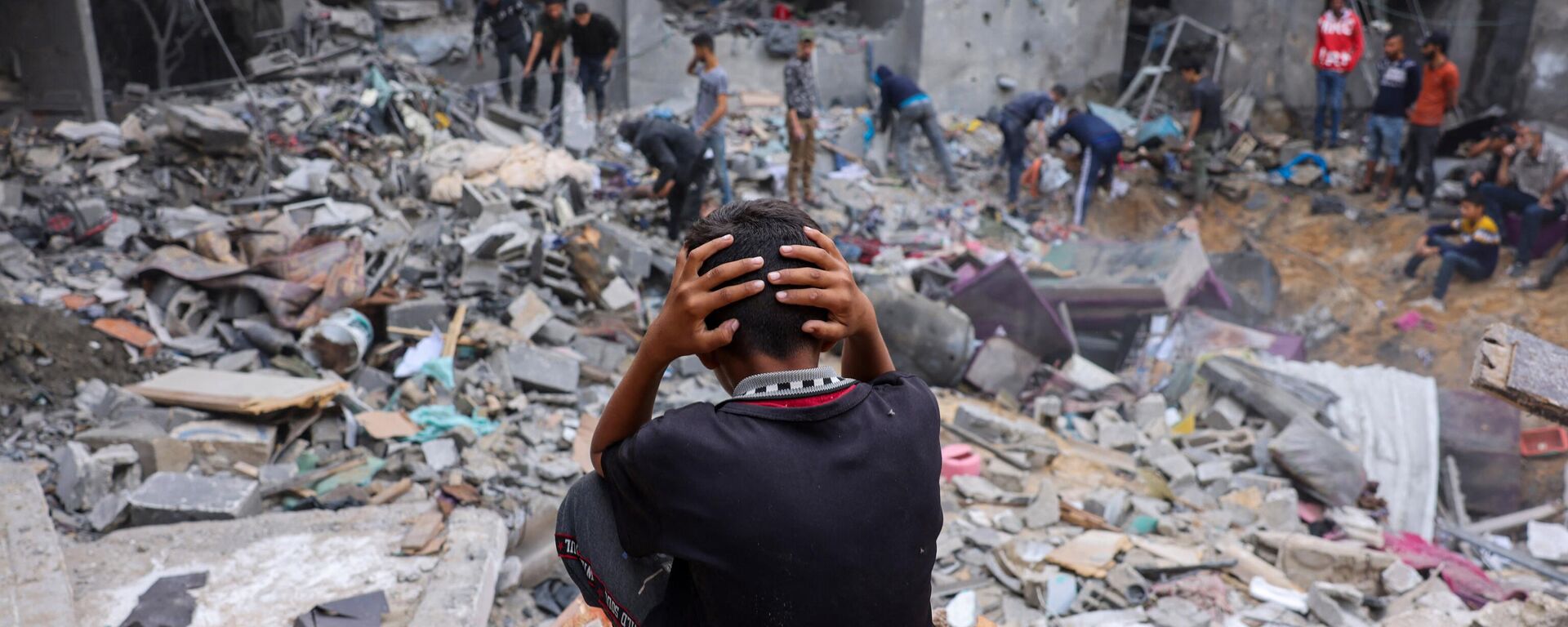 Đứa trẻ giữa đống đổ nát của tòa nhà bị hư hại sau những trận tấn công vào Rafah ở phía nam Dải Gaza - Sputnik Việt Nam, 1920, 14.11.2023