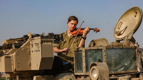 Một người lính Israel chơi violin trong một chiếc xe tăng ở phía nam Israel gần biên giới với Dải Gaza - Sputnik Việt Nam