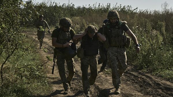 Quân nhân Ukraina giúp sơ tán một thương binh ở Ukraina vào ngày 30/8/2023. - Sputnik Việt Nam