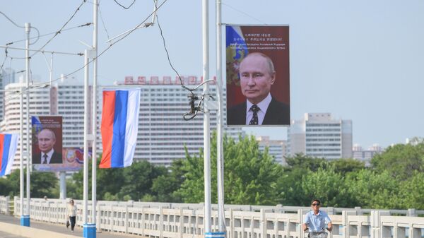 Biểu ngữ có chân dung Tổng thống Nga Vladimir Putin và cờ Nga trên đường phố ở Bình Nhưỡng - Sputnik Việt Nam