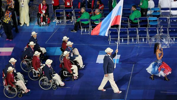 Người mang quốc kỳ của đội tuyển Paralympic Nga Alexey Ashapatov (bên phải) tại lễ khai mạc Paralympic mùa hè ХIV trên sân vận động Olympic ở London. - Sputnik Việt Nam