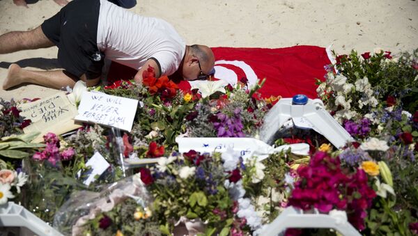 Một người hôn lên lá cờ Tunissia để tưởng nhớ các nạn nhân thiệt mạng trong vụ khủng bố - Sputnik Việt Nam