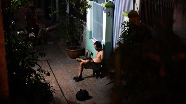 Người đàn ông đang ngồi  trước nhà ở thành  phố Hồ Chí Minh, Việt Nam. - Sputnik Việt Nam