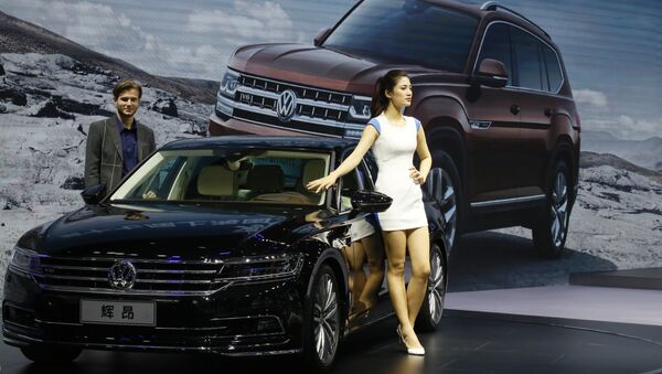 A female worker poses near cars from SAIC Volkswagen during the Auto Shanghai 2017 show at the National Exhibition and Convention Center in Shanghai, China, Thursday, April 20, 2017 - Sputnik Việt Nam