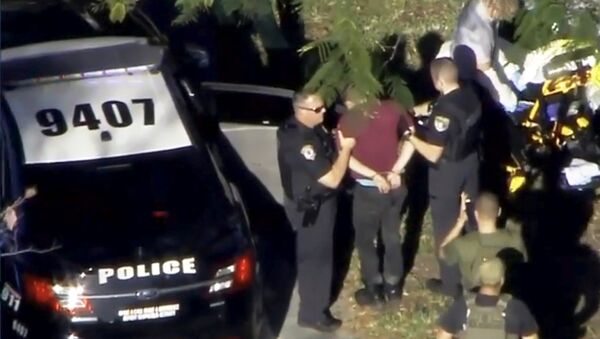 A man placed in handcuffs is led by police near Marjory Stoneman Douglas High School following a shooting incident in Parkland, Florida, U.S. February 14, 2018 in a still image from video - Sputnik Việt Nam