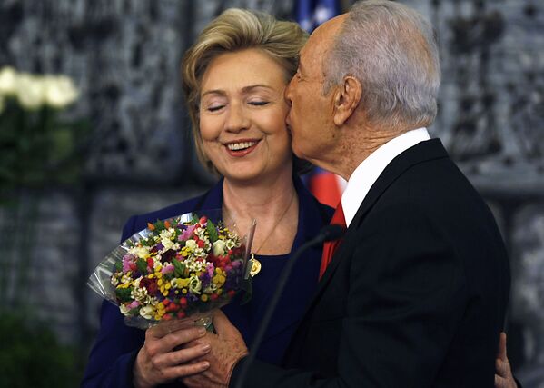 Tổng thống Israel Shimon Peres ôm hôn Ngoại trưởng Mỹ Hillary Clinton, tặng bà bó hoa sau cuộc họp báo chung ở Jerusalem, năm 2009 - Sputnik Việt Nam