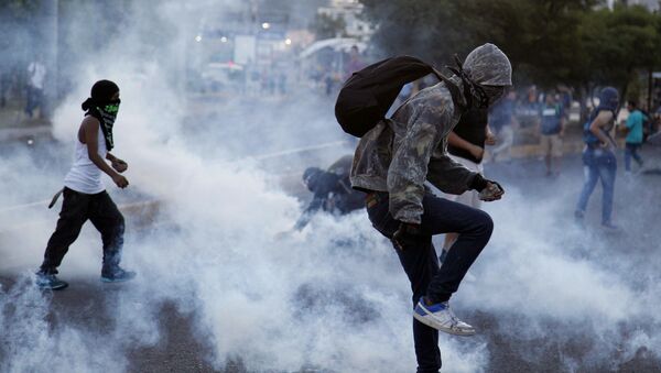 Протестующие против поднятия цен на общественный транспорт и бензин во время столкновения с полицией в Тегусигальпе, Гондурас - Sputnik Việt Nam