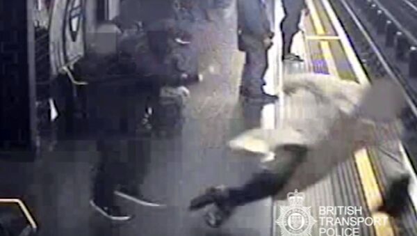 This handout grab taken from CCTV issued by British Transport Police shows Robert Malpas being pushed onto the tracks of Marble Arch Underground station in London - Sputnik Việt Nam