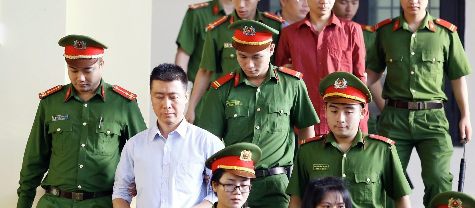 Bị cáo Phan Sào Nam (áo trắng) cùng các bị cáo được cơ quan chức năng dẫn giải ra tòa. - Sputnik Việt Nam, 1920, 22.11.2018