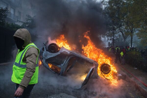 Chiếc xe bị đốt cháy trong phong trào biểu tình phản đối áo ghi lê vàng ở Paris - Sputnik Việt Nam