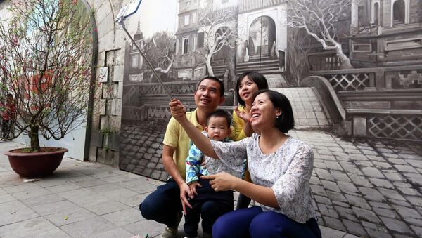 Người dân thủ đô du xuân và chụp ảnh lưu niệm tại phố Bích Hoạ - Phùng Hưng. - Sputnik Việt Nam
