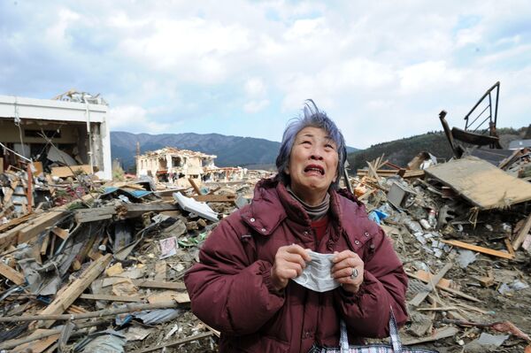 Пожилая женщина плачет у разрушенного здания городе Рикудзентаката черNgười phụ nữ lớn tuổi khóc gần tòa nhà bị phá hủy của thành phố Rikudentakata, tám ngày sau trận động đất và sóng thần tấn công đất nước Nhật Bản ngày 11 tháng 3 năm 2011.ез восемь дней после землетрясения и цунами, обрушившихся 11 марта 2011 года на Японию - Sputnik Việt Nam