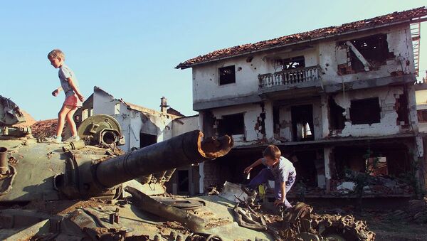 Trẻ em chơi trên chiếc xe tăng Serbia bị phá hủy trong vụ bắn phá của NATO tại thành phố Klina của Nam Tư, 1999 - Sputnik Việt Nam